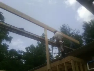 Carpenter setting a ridge beam over a new addition frame — Ice Dam Removal by Roofing Brothers in Opp
