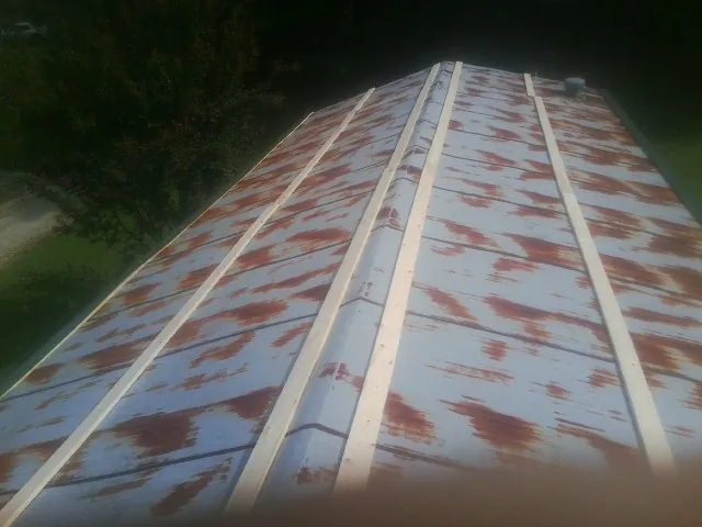 Rusted metal roof panels with new wood purlins before replacement — Storm Damage Roof Repair in Opp by Roofing Brothers