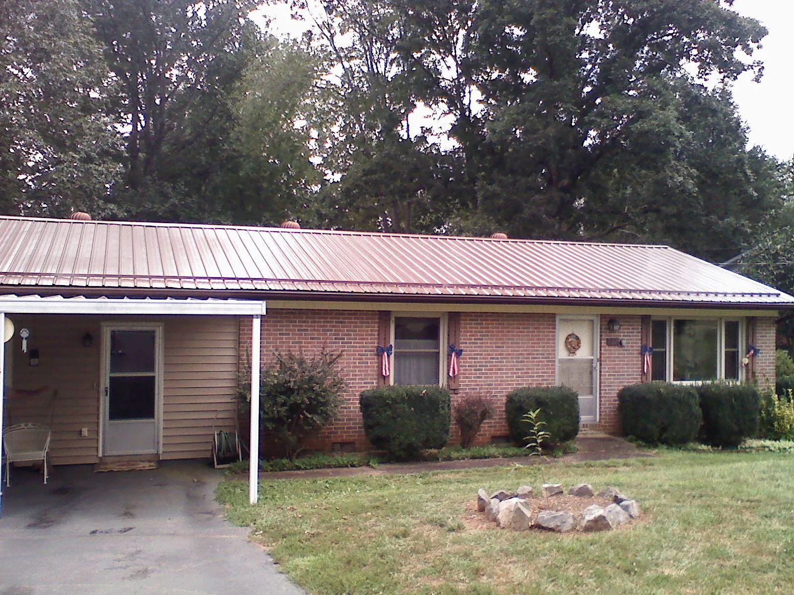 Bronze metal roof and carport on a brick ranch home — Roof Repair work by our crew in Opp