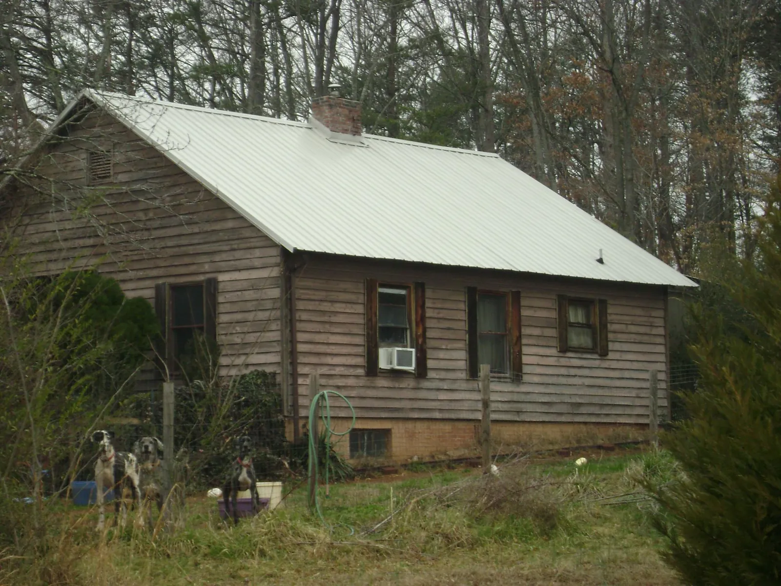 White metal roof on an old wood sided farmhouse, from a Metal Roof Installation job in Opp